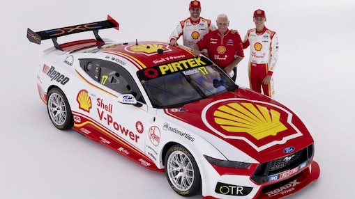 Shell V-Power branded race car displayed in a studio setting with Dick Johnson, Brodie Kostecki, and Rylan Grey standing beside the vehicle.