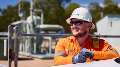 A worker in front of a Shell QGC gas well site in Queensland.