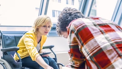 Woman in a wheelchair talking to a man