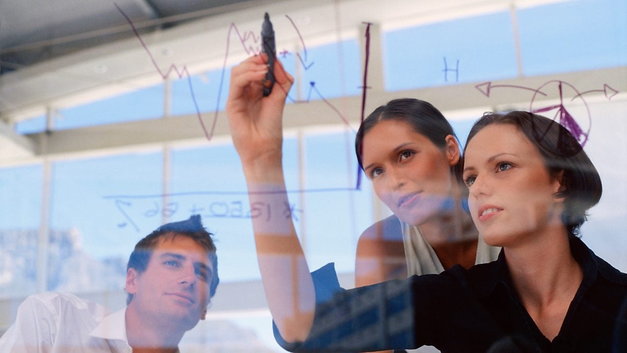 Businesswoman drawing graphs on glass