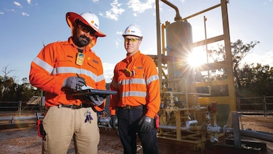 QGC wellsite operators check well performance.