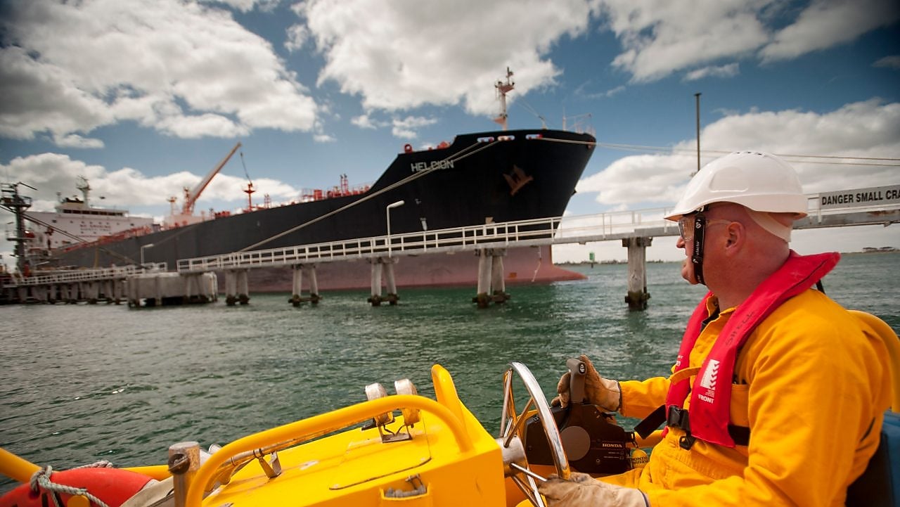 Jetty worker manning response vessel next to tanker