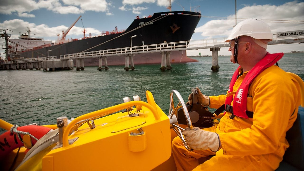 Jetty worker manning response vessel next to tanker