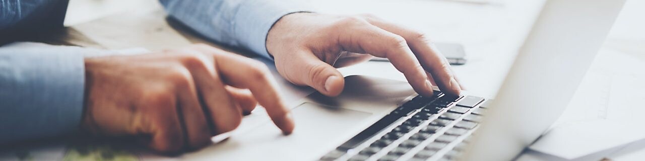 Laptop, mobile phone and paperwork on work desk.