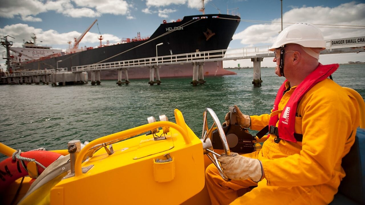 Jetty worker manning response vessel next to tanker