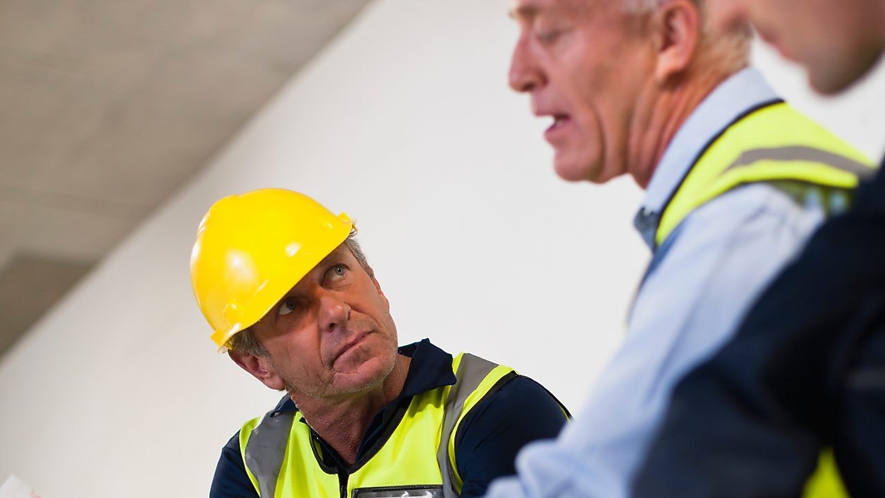 People in hardhats reviewing documents