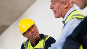 People in hardhats reviewing documents