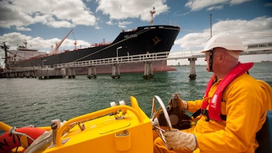 Jetty worker manning response vessel next to tanker
