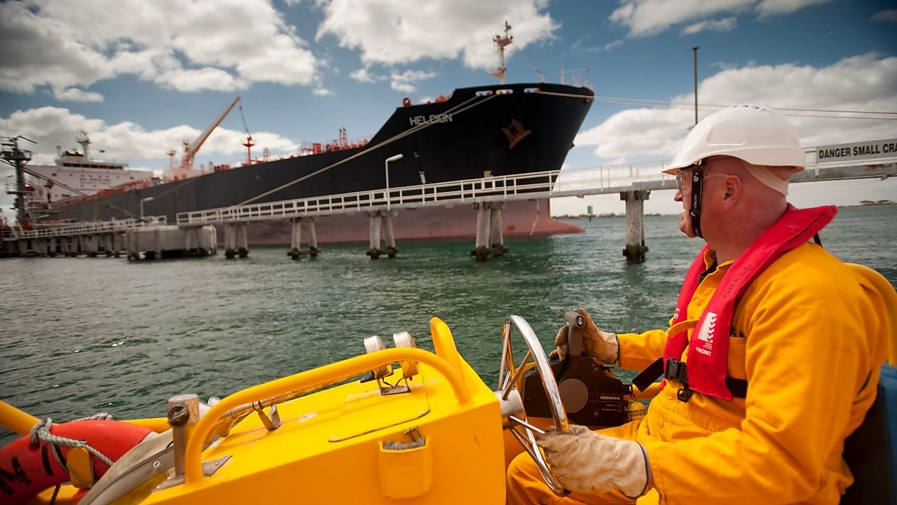 Jetty worker manning response vessel next to tanker