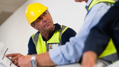 People in hardhats reviewing documents