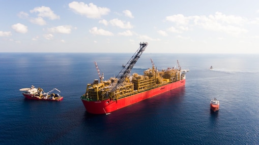 Ariel view of Prelude FLNG in the ocean with tugs.
