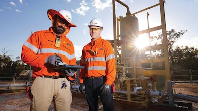 QGC wellsite operators check well performance.