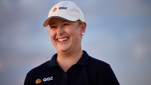 A Shell employee in QGC branded uniform smiles off camera.