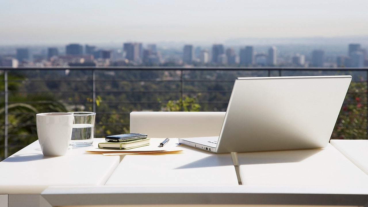 Laptop and paperwork on balcony table