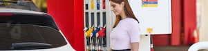 Woman refueling her car at a Shell Coles Express station