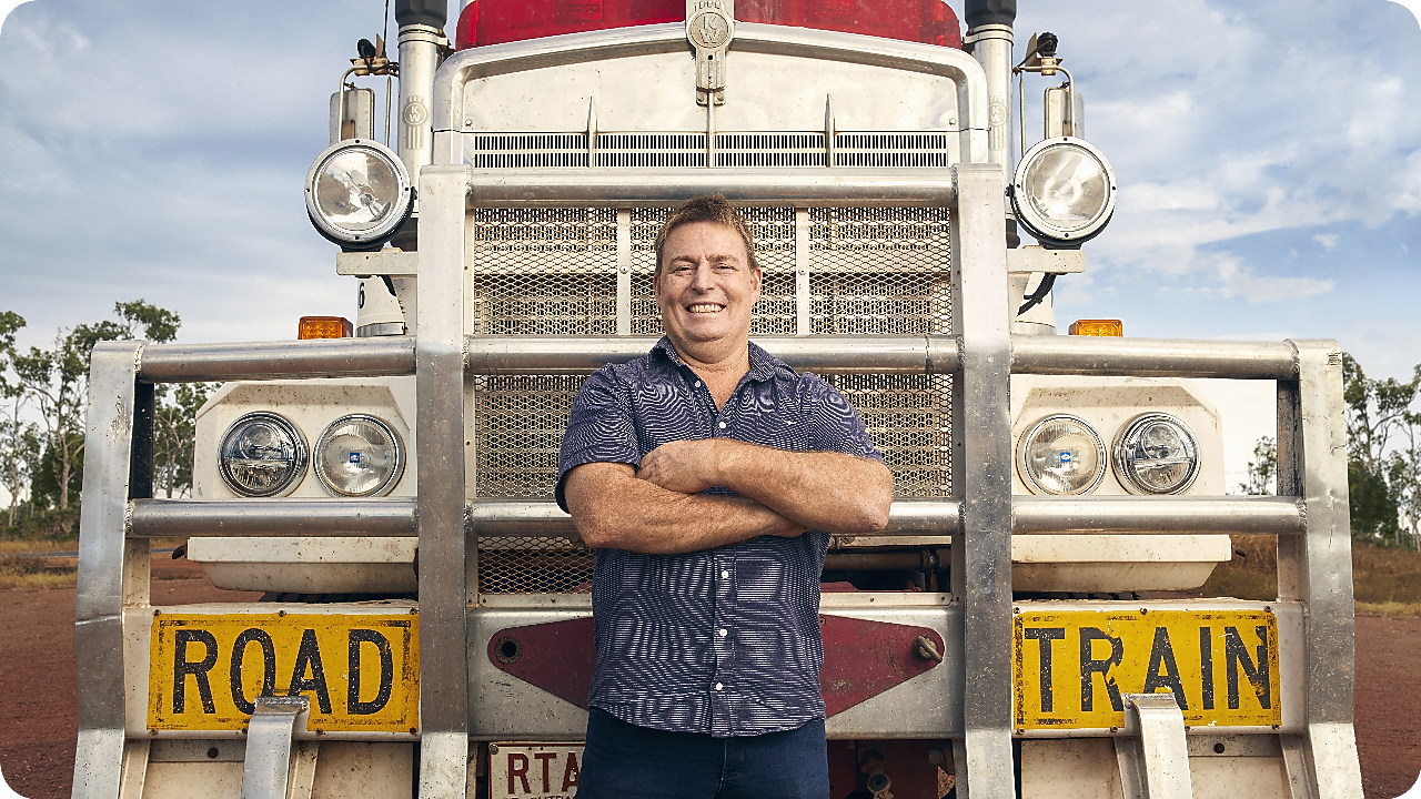 Man proudly standing in front of his truck.