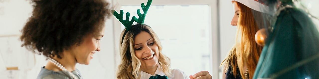 Three colleagues celebrate Christmas at work