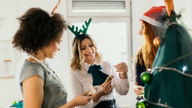 Three colleagues celebrate Christmas at work