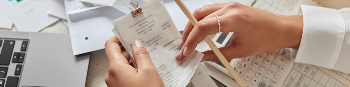 hands holding receipts with paper in the background