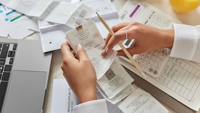 hands holding receipts with paper in the background
