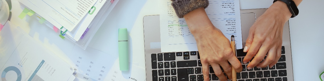 Accountant woman with documents and laptop working.