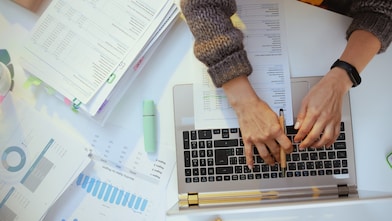 Accountant woman with documents and laptop working. 