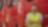 A man stands confidently in front of a lineup of red trucks, showcasing their vibrant color and sturdy design.