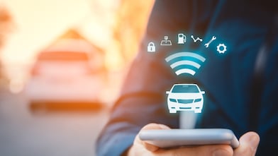 Intelligent car app on smart phone concept, intelligent vehicle and smart cars concept. Person with smart phone on street, car in background and wireless communication with car.