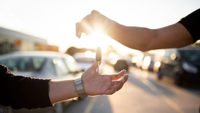 Person handing over keys to another person