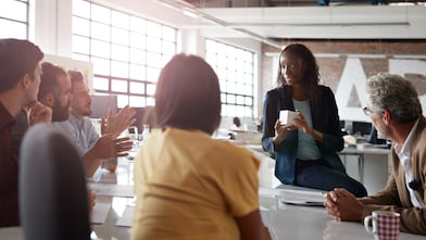 A manager talks to her team in the office.