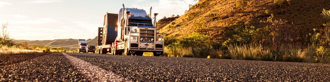 A low-angle view of a truck driving on a remote Australian road