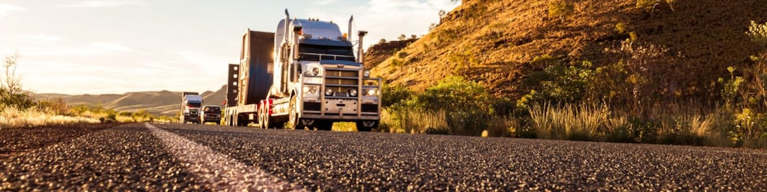 A low-angle view of a truck driving on a remote Australian road