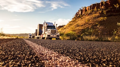 A low-angle view of a truck driving on a remote Australian road