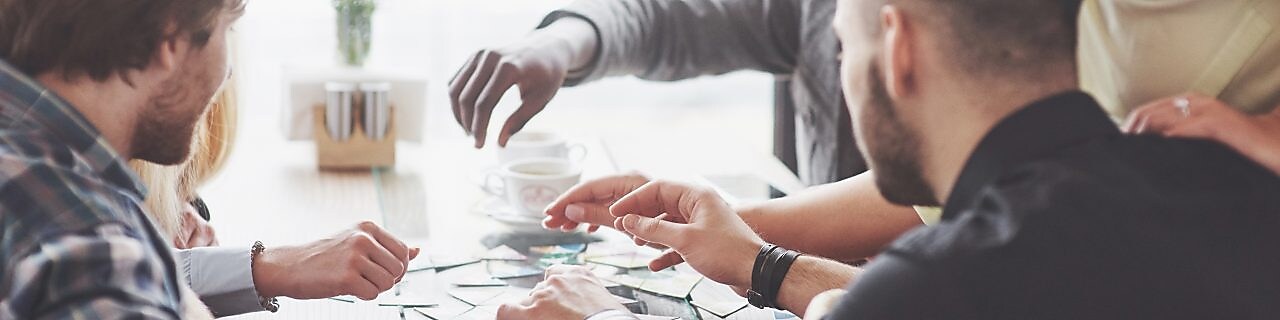 A team of colleagues sit around a table completing an activity.