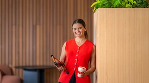 person standing indoors against a light wooden wall with vertical grooves