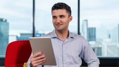 An individual in a workplace using a tablet