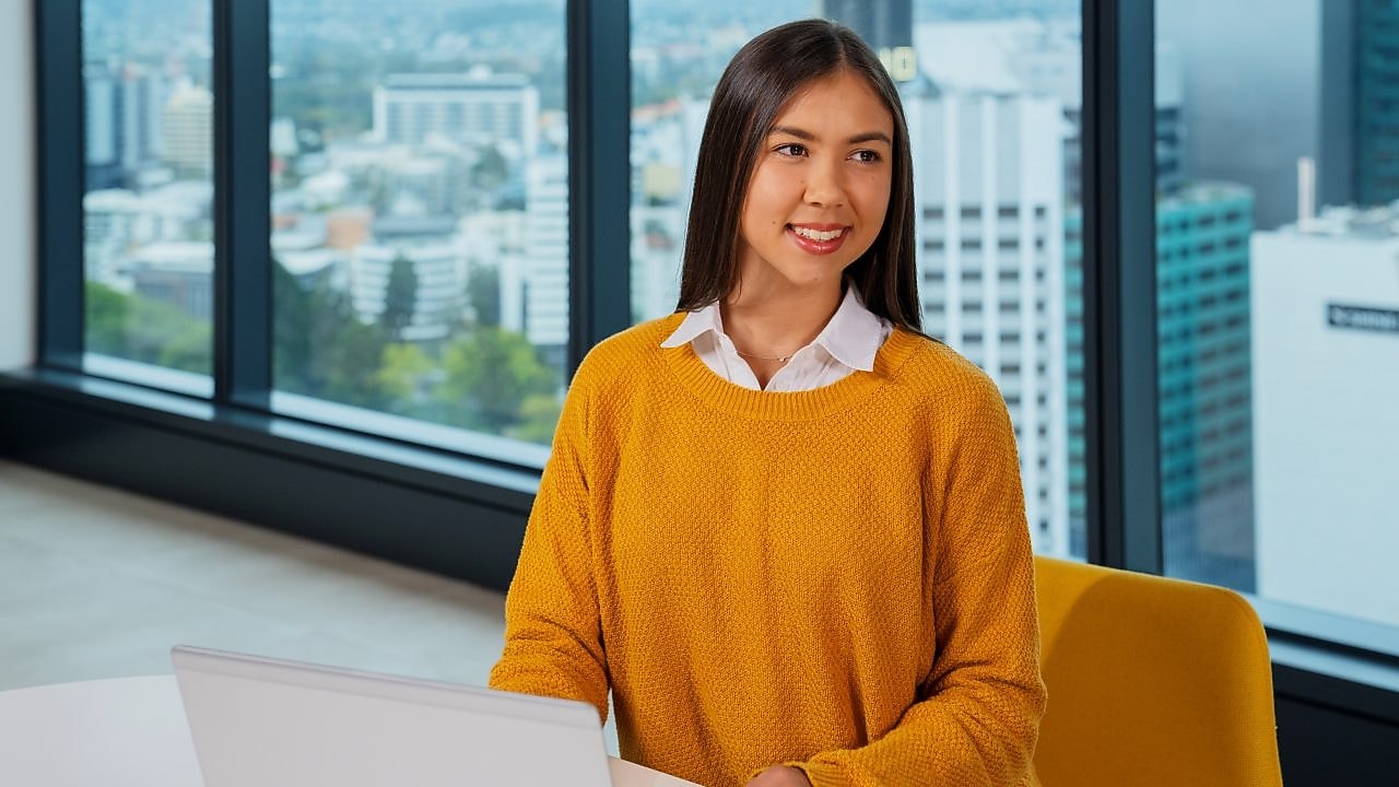 An individual seated at a table, using a laptop