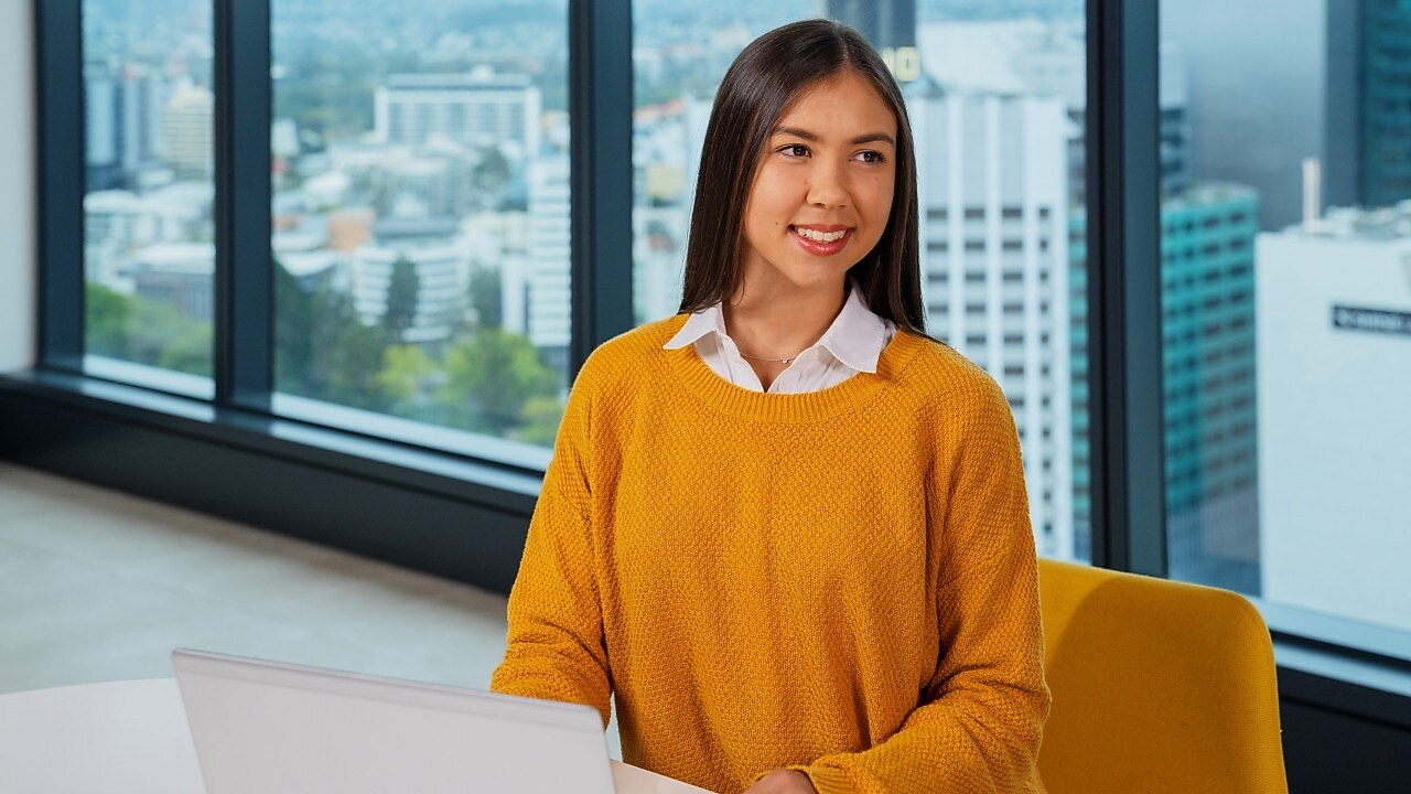 An individual seated at a table, using a laptop
