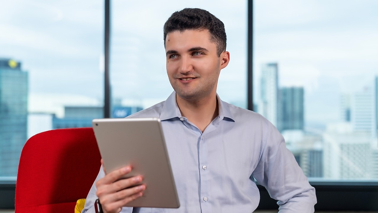 An individual in a workplace using a tablet