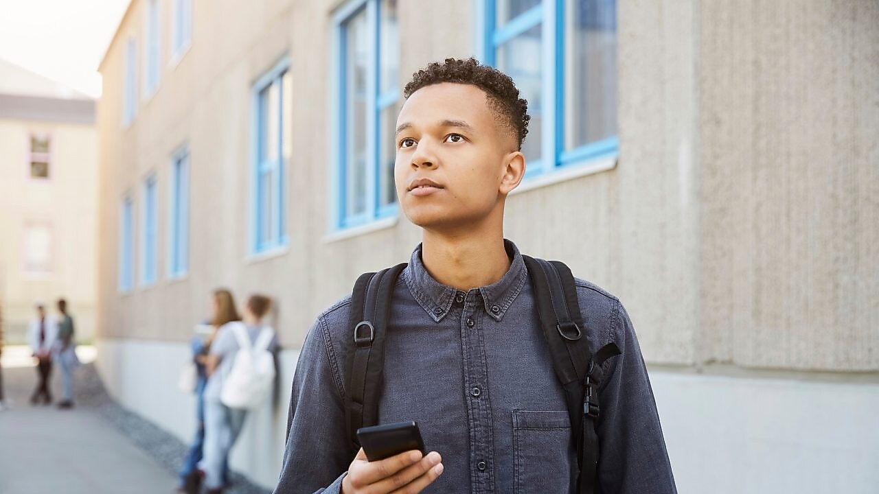 a male student wearing a backpack. 