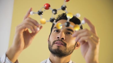 Young man examining molecular model