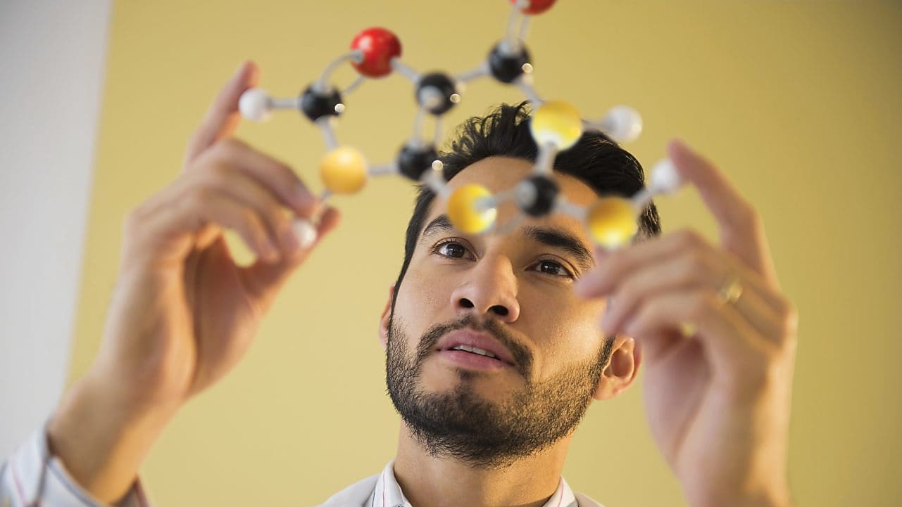 Young man examining molecular model