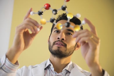 Young man examining molecular model