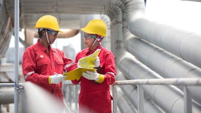 Employees on site discussing work and referring to clipboard
