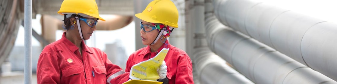Employees on site discussing work and referring to clipboard
