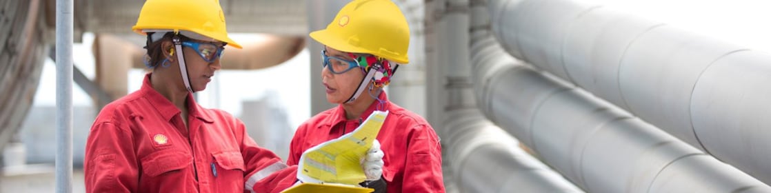 Employees on site discussing work and referring to clipboard