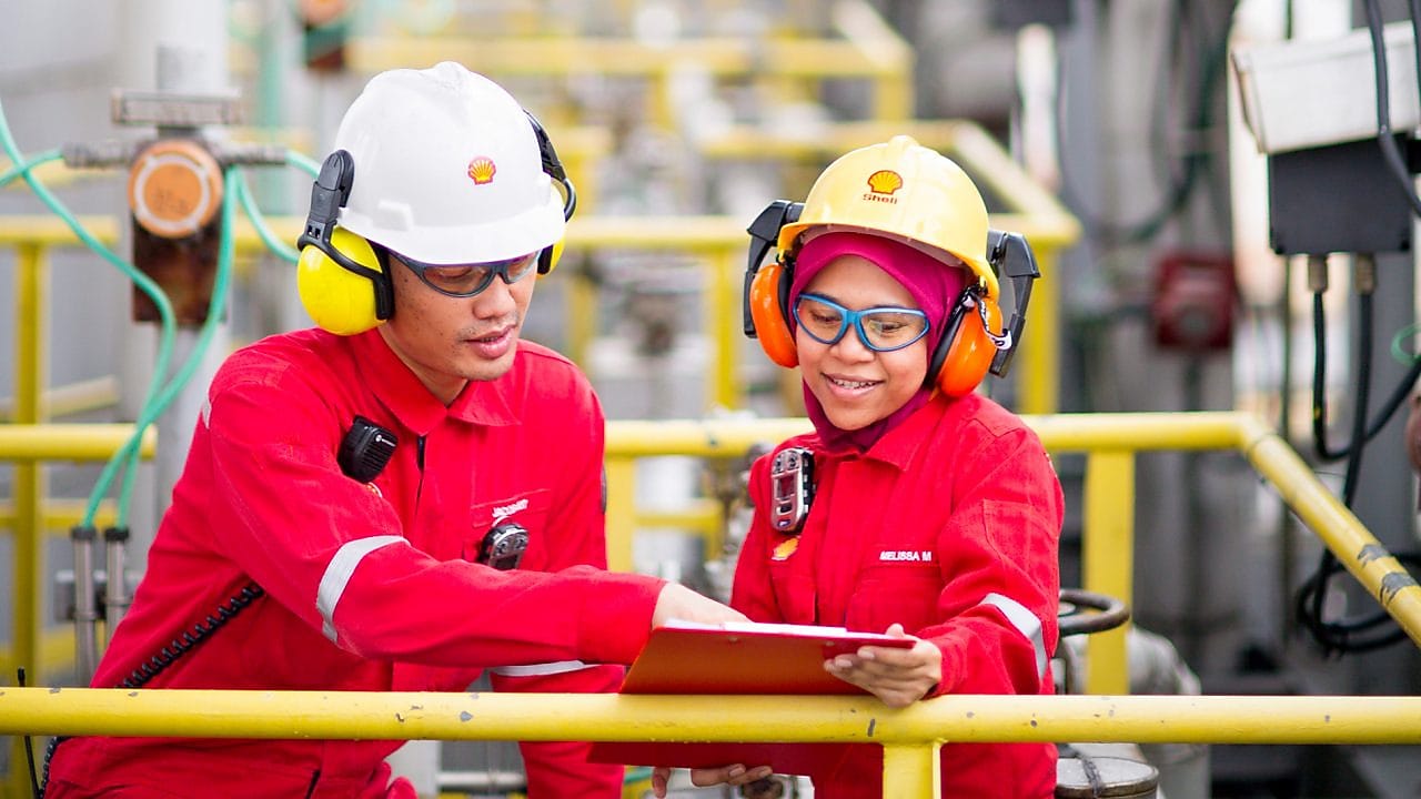 Colleagues onsite at meeting and refering to notes on clipboard