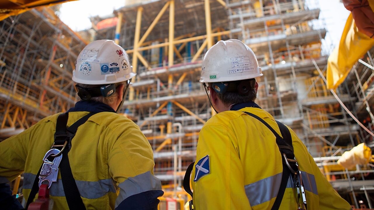 Two men looking at construction of a platform