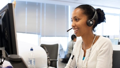 Woman in call centre facing her computer screen