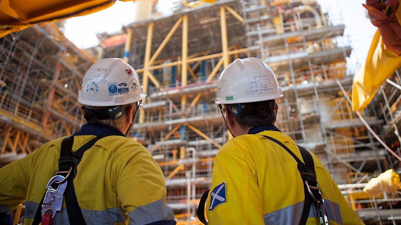 Two men looking at construction of a platform